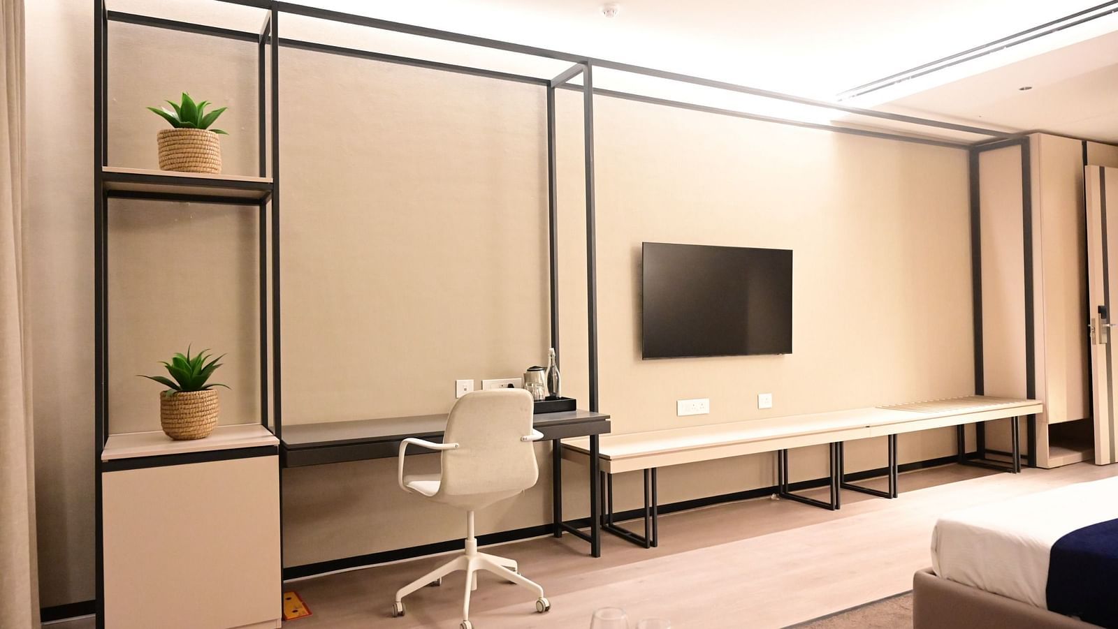 image featuring a work desk along with a wall mounted television in a room at club charholi, pune